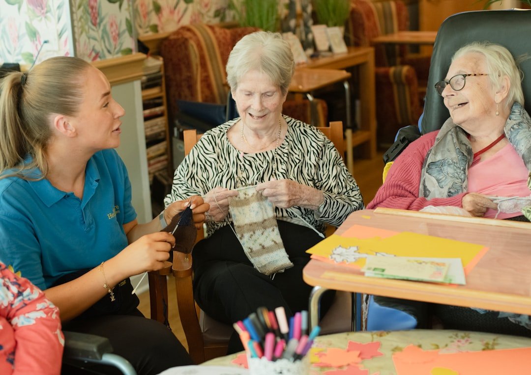 caregiver-assists-two-elderly-women-knitting-gstffdroygo